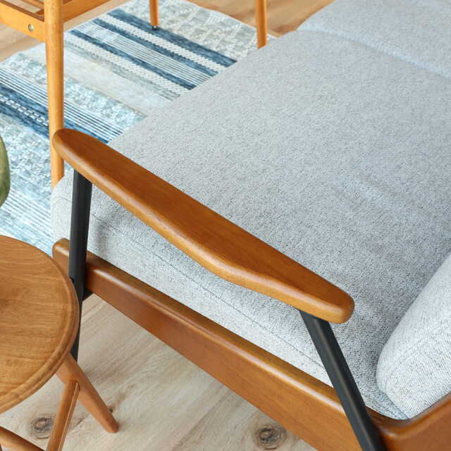 曲線を帯びた木製アームレストのソファ