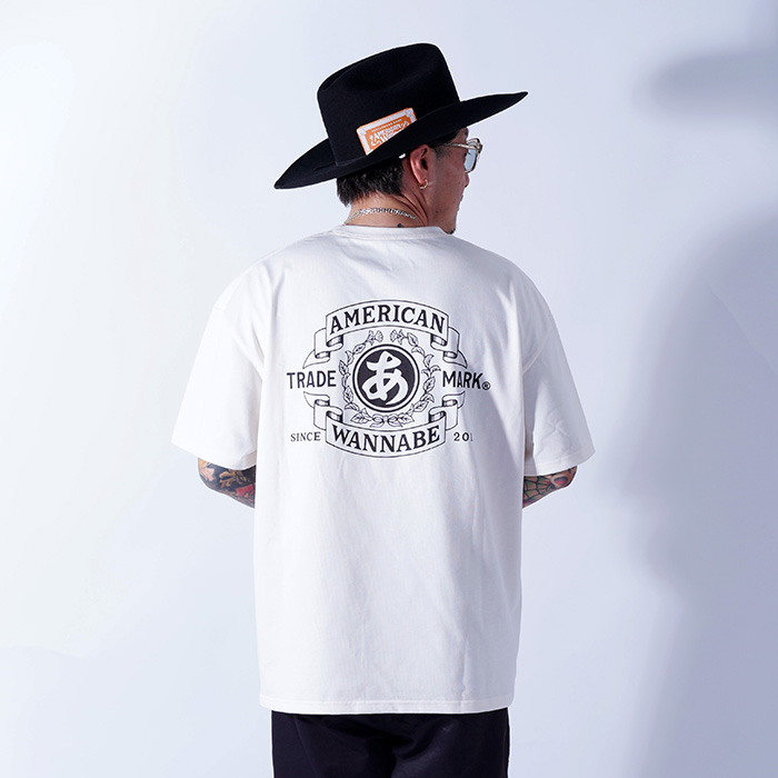 AMERICAN WANNABE/アメリカンワナビー「TRADE MARK S/S TEE / IVORY」プリントS/S Tシャツ