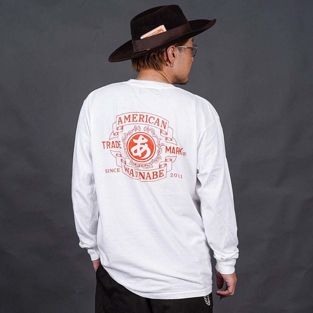 THE AMERICAN WANNABE/アメリカンワナビー「TRADE MARK L/S TEE / WHITE」プリント長袖Tシャツ