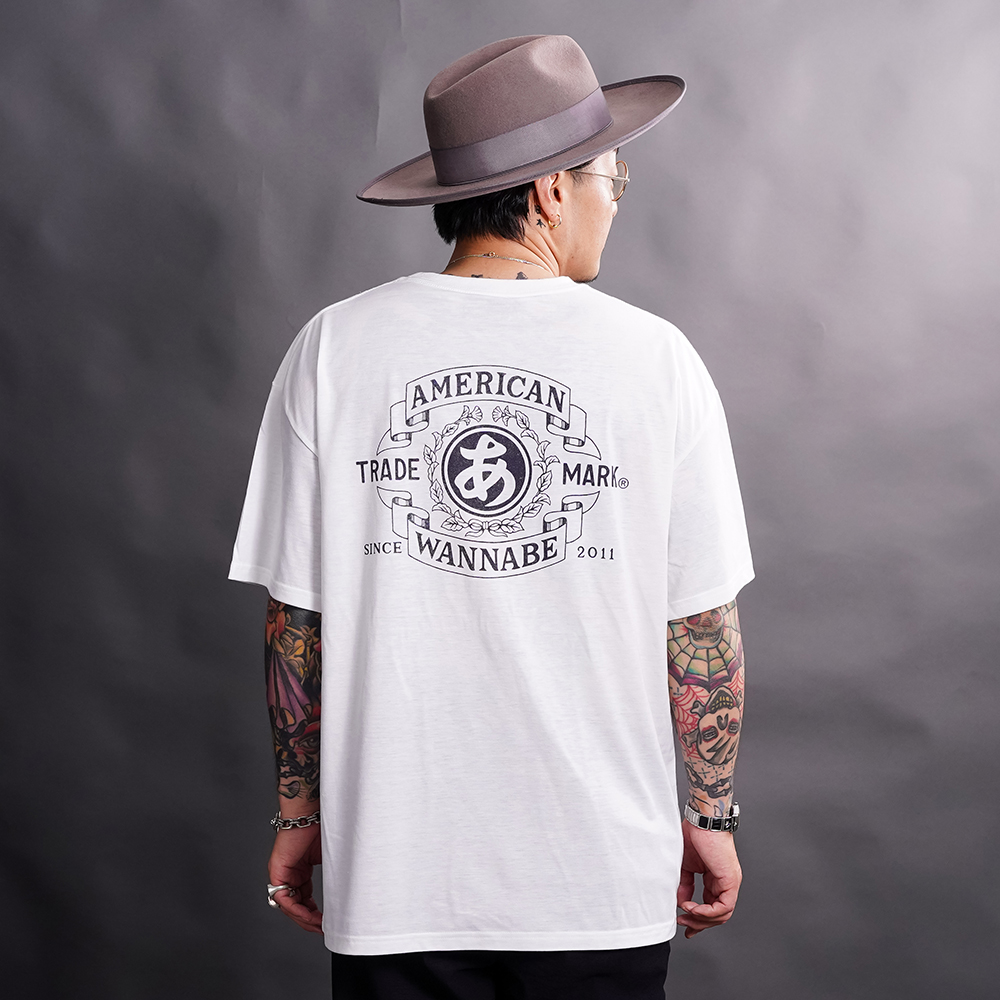 THE AMERICAN WANNABE/アメリカンワナビー「TRADE MARK S/S TEE / WHITE」プリントS/S Tシャツ