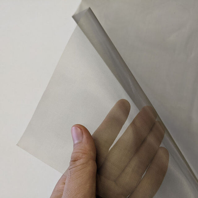 透視性シールドメッシュ50dBを手で触っている