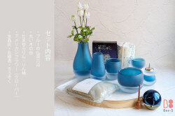 落ち着いたブルーのガラス仏具と小物のフルセット。丸い木の台に、花瓶やおりん、お線香などが美しく配置されたお仏壇セット