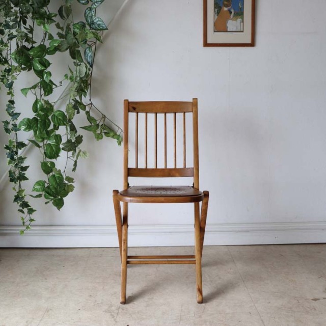 折りたたみ式の木製の椅子、座面には花柄の文様、色はライトブラウン、022031a