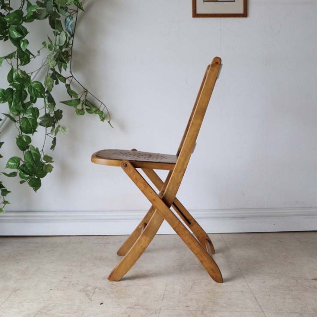 折りたたみ式の木製の椅子、座面には花柄の文様、色はライトブラウン、022031a