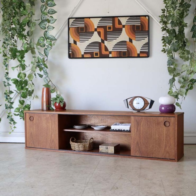 茶色のテレビ台、脚はないローボード、真ん中は棚があり両サイドは丸い取っ手の扉がある　122112