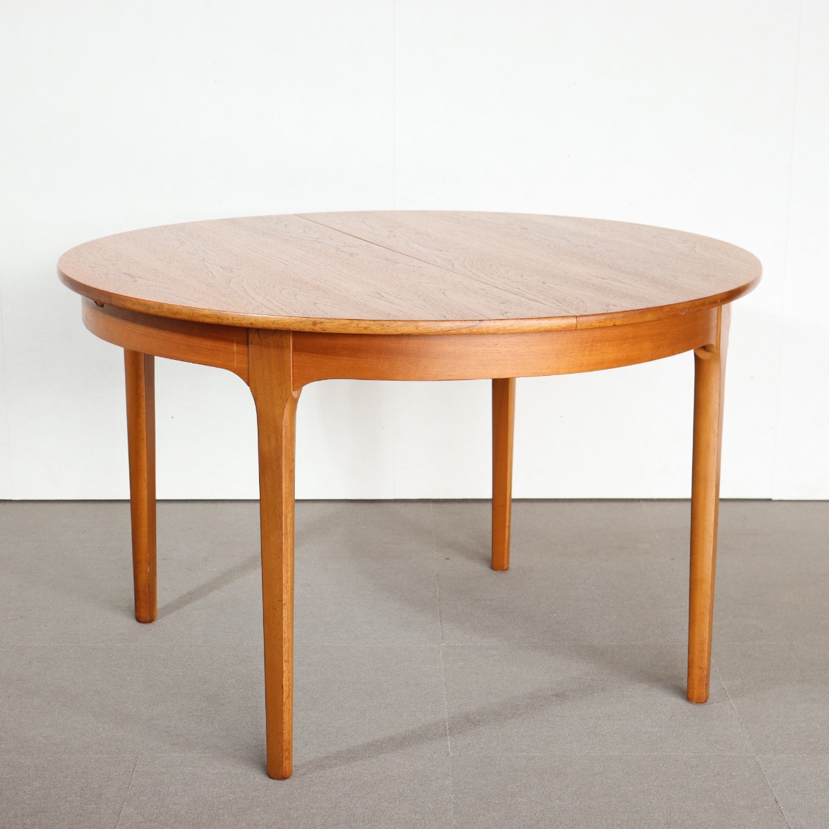 ネイサンラウンドダイニングテーブル。チーク材の豊かな色合いが魅力のヴィンテージ。高級感ある佇まい。