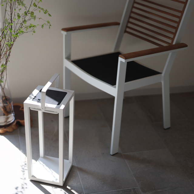 日が差し込む窓際で、花瓶に飾られている高木の枝の葉の影がリヒトルクスフロアホワイトに落ちている