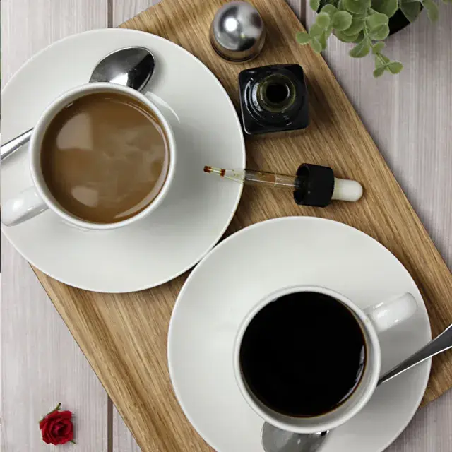 2つのコーヒーカップとプロポリスボトル。スポイトでプロポリスをコーヒーに加える使用例