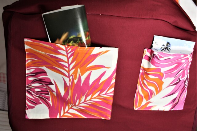 生成り地にピンク、オレンジ。えんじの大きなラウアエの葉模様がすてきなポケットいっぱいのバッグ