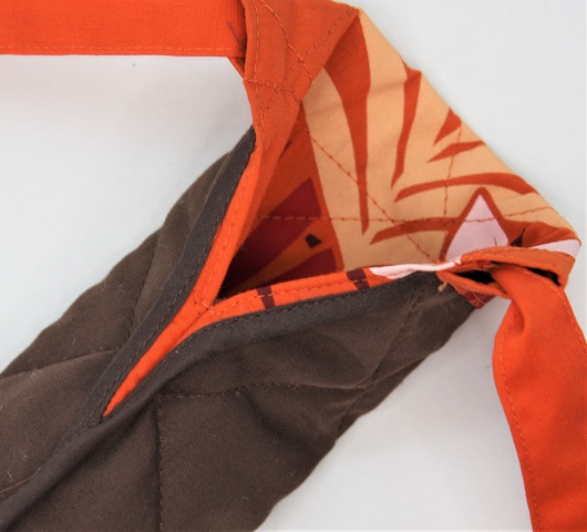 オレンジ地に、白、クリ－ム色のプルメリア模様と茶、赤の葉模様がおしゃれな、カラアウケース