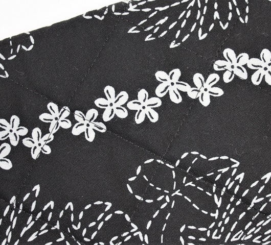 黒地にボーダ－の、刺し子風白い小花模様のプイリケ－ス