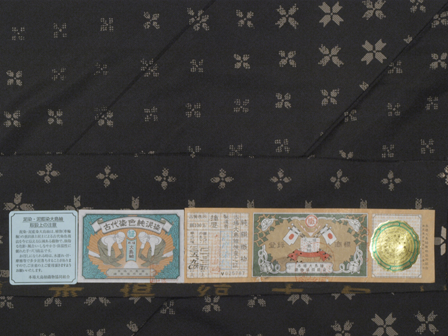 帯のアトリエ花邑 Hanamura 銀座店 憲法黒茶 けんぽうくろちゃ 色地に幾何学花文様 本場大島紬 泥染め 袷 証紙付き