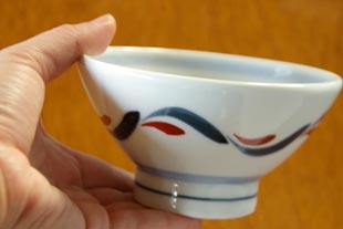 砥部焼・岡田陶房　赤波紋の茶碗を手に持って