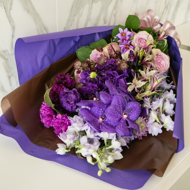 ブーケは香りの花 リューココリーネ と蘭を使い 豪華なパープル系の色合いでお作りします