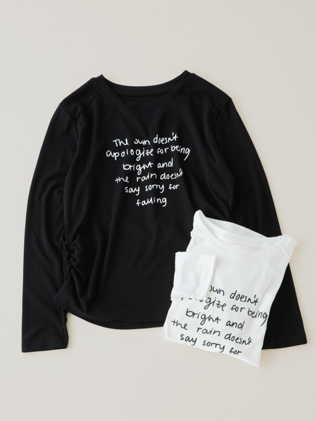 黒のロゴ入り長袖Tシャツの上に畳まれている白のロゴ入りTシャツの写真