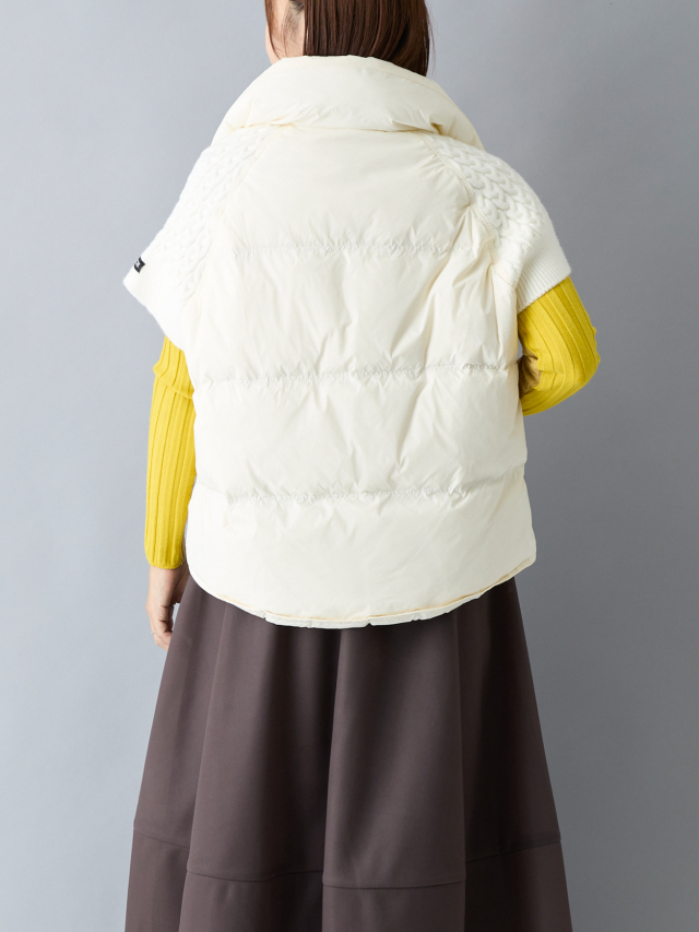 黄色いニットに白いダウンベストを重ねている女性の後ろ上半身