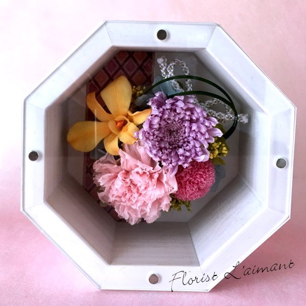縁起が良いといわれる八角形の花器に優しい色合いのプリザをあしらった