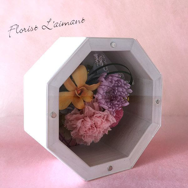 縁起が良いといわれる八角形の花器に優しい色合いのプリザをあしらった