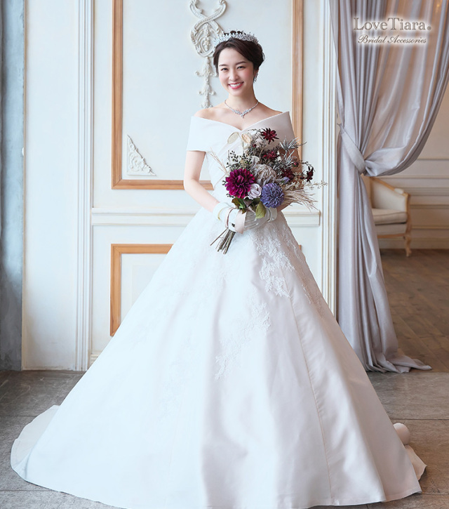 高めシニヨンヘアとネックレスと合わせた女性のイメージ