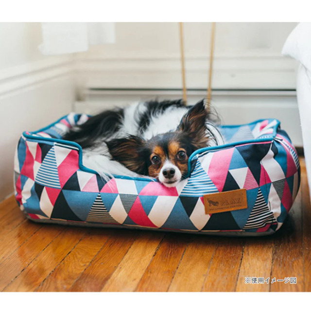 P.L.A.Y. プレイ ラウンジベッド（アーティストコレクション） モザイク (ソーダポップ, サイズ：M)の上で寝そべる犬