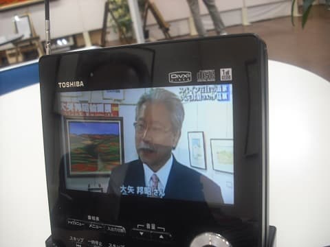 大矢邦昭絵画展　テレビの取材を受ける画家