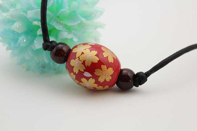 有田焼磁器玉皮紐ペンダント(フリー) 楕円  赤釉金彩桜