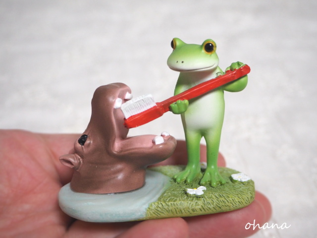 カバの歯磨きをするカエル