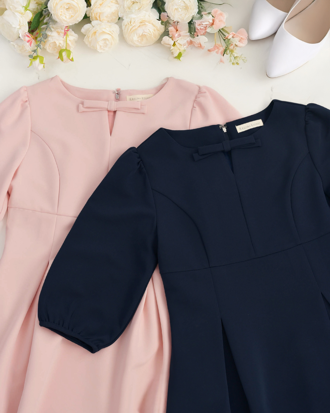 ピンクとネイビーのワンピースを並べた画像。可愛らしいリボン付きデザインとエレガントな雰囲気が伝わる上品なワンピース　レジーナ【神戸ワンピース専門店】