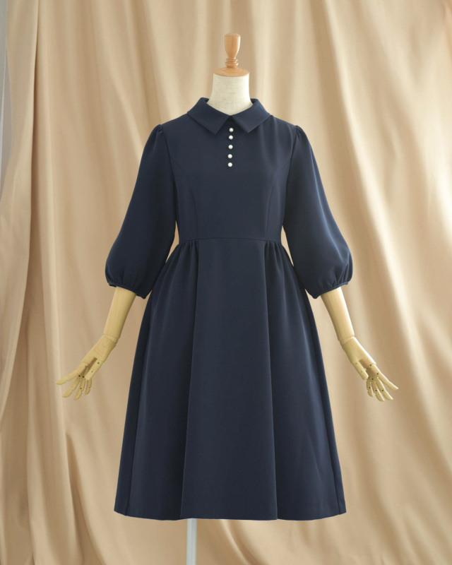 清楚な襟元と上品なパールが映える、落ち着きのあるネイビーワンピース