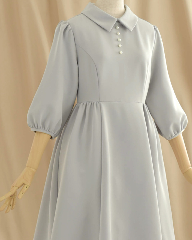 グレーのパールボタンワンピース、清楚でエレガントな印象を与える一枚