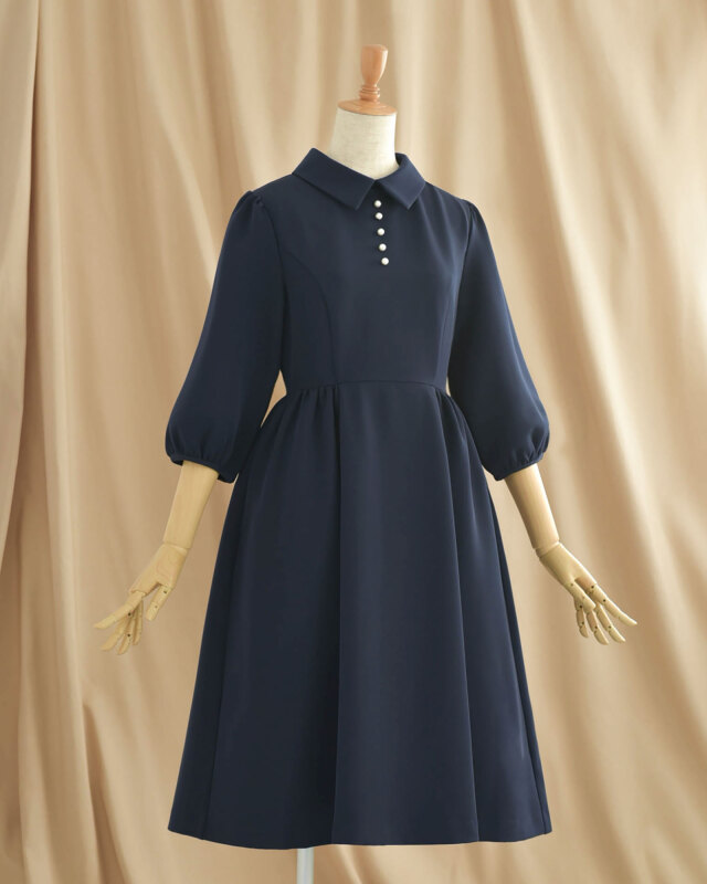 ネイビーのパールボタンワンピース、落ち着いた色合いでエレガントな印象を与えるデザイン