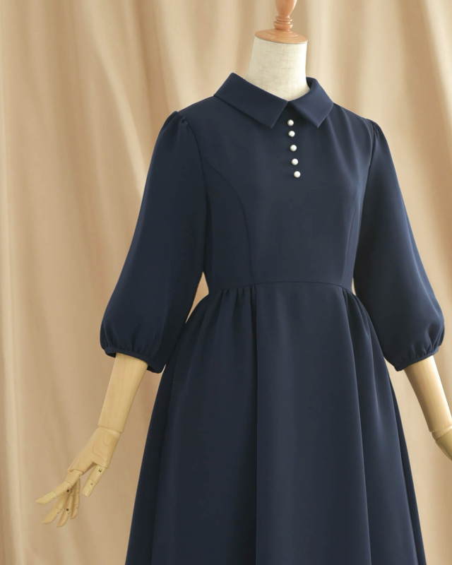 ネイビーのパールボタン付きワンピース、大人の女性に似合う上品でクラシカルなデザイン