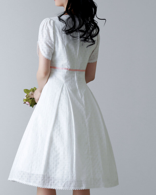 背中まで美しいシルエットが映えるホワイトレースワンピースを着用した女性の後ろ姿。可憐で清楚な印象。レジーナ【神戸ワンピー