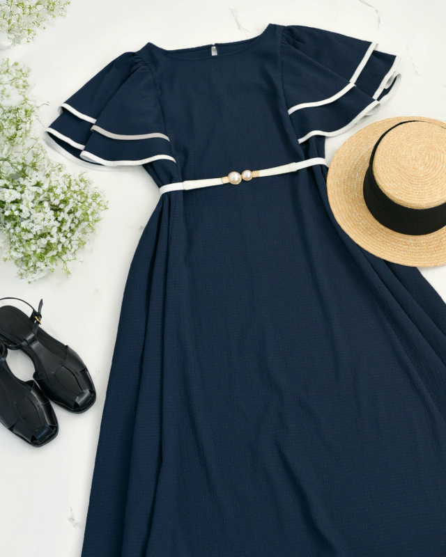 深いVネックが美しく映えるネイビーのワンピースを気品ある雰囲気で着こなす女性