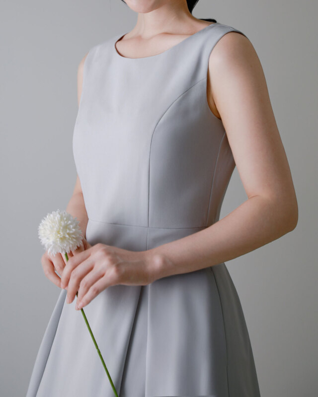 ノースリーブスタイルに切り替え可能な2wayワンピースを着用した女性の姿。すっきりとした上半身のシルエット。レジーナ【神