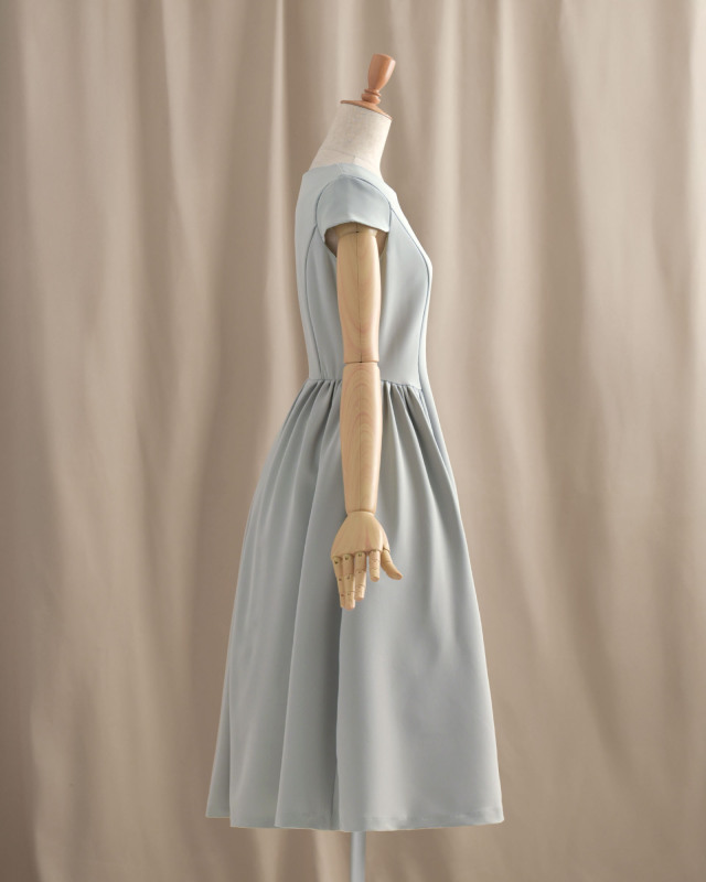 体のラインを拾わないフレアワンピース（ペールグレー）の横から見たシルエット。