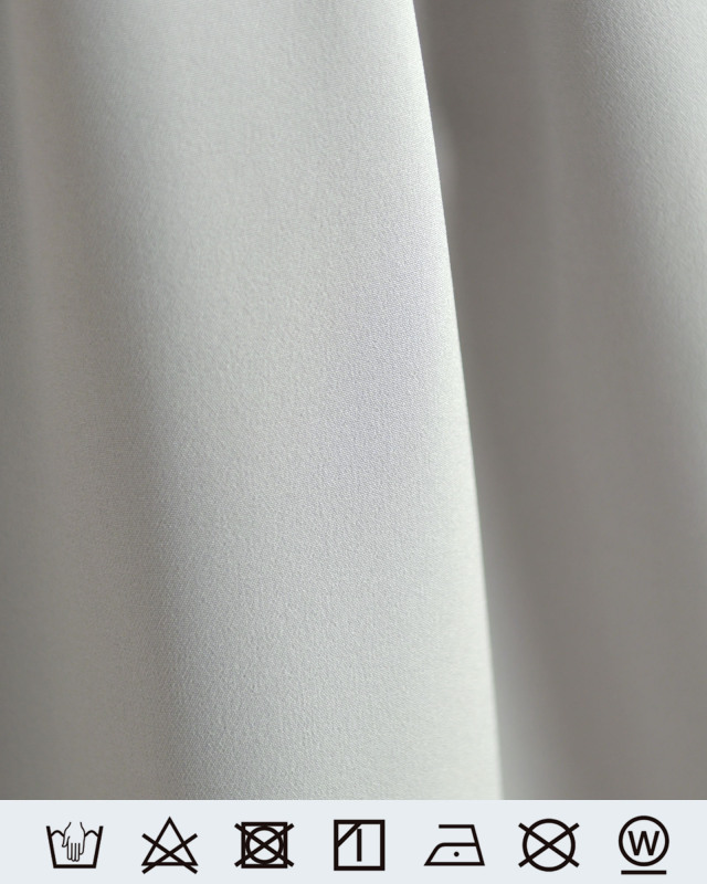 ペールグレーの生地アップと家庭での手洗い、アイロンなどの洗濯表示。