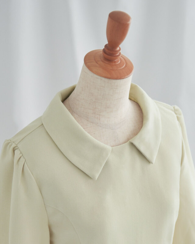 立ち上がりのある襟が上品な印象を添えるきれいめAラインワンピースのネックデザイン