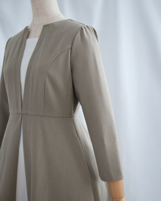 デコルテをすっきり見せるノーカラーデザインで、顔まわりが上品に映えるきれいめワンピース。