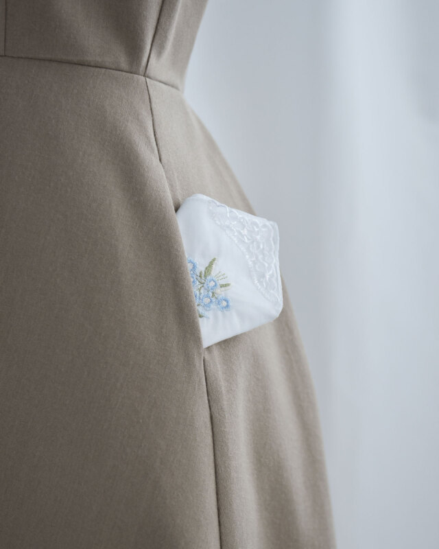 ポケット内側にさりげないレースを施し、実用性と大人の可愛らしさを兼ね備えた一着。