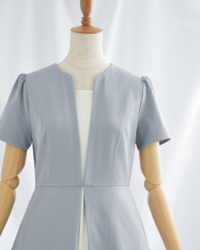 胸元のカッティングがデコルテを美しく見せる。上品で洗練された印象を与える大人のきれいめワンピース。