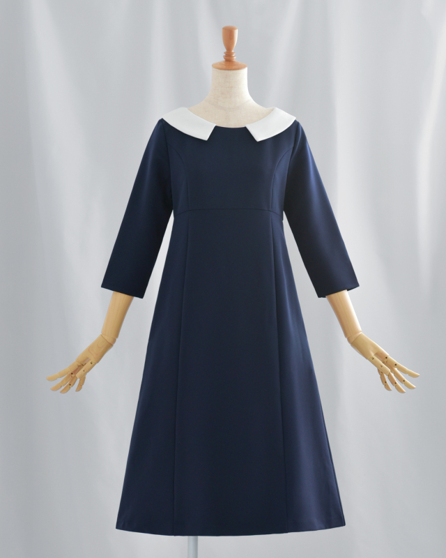 白襟が顔周りを明るく映すネイビーのAラインワンピース。大人の女性に似合う上品で清楚な印象。