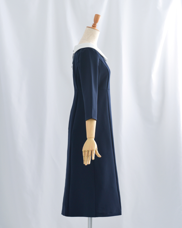 白襟付きネイビーワンピースの横姿。落ち着きのある清楚な印象で大人女性のフォーマルシーンに最適。
