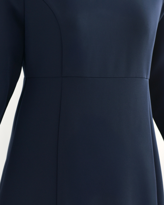 ネイビーワンピースのウエスト切り替え部分のアップ。体のラインを美しく見せるシルエット設計。