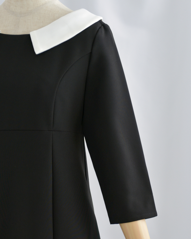 ブラックワンピースの袖ディテール。シンプルで洗練された印象を演出。