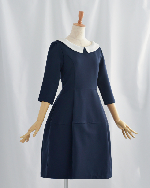 ホワイトの襟が映えるネイビーワンピースのフロントデザイン。体型をすっきり見せるシルエットで大人の女性に人気。