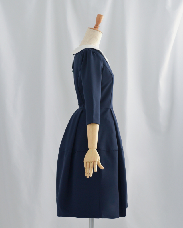 側面から見たネイビーワンピース。ウエストラインが美しく、ホワイトカラーが顔周りを明るく見せる大人のきれいめワンピース。