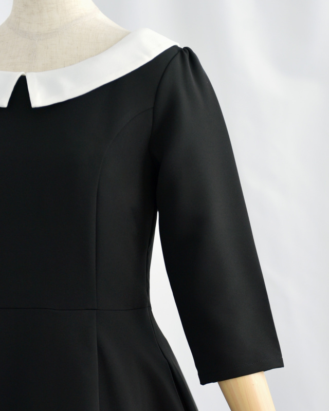 上品な黒ワンピースの七分袖デザイン、フォーマルにも日常にも映えるシルエット
