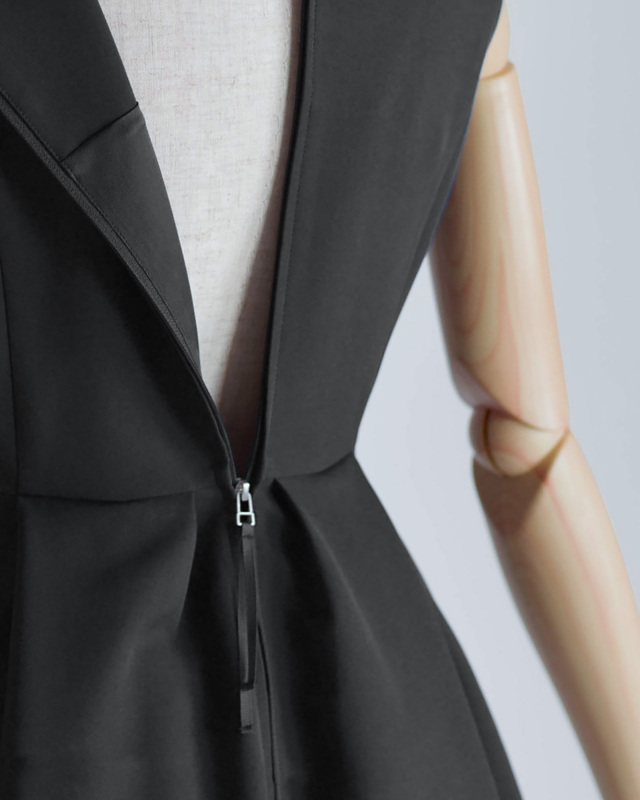 後ろファスナー仕様の黒ワンピース、着脱しやすくエレガントな印象