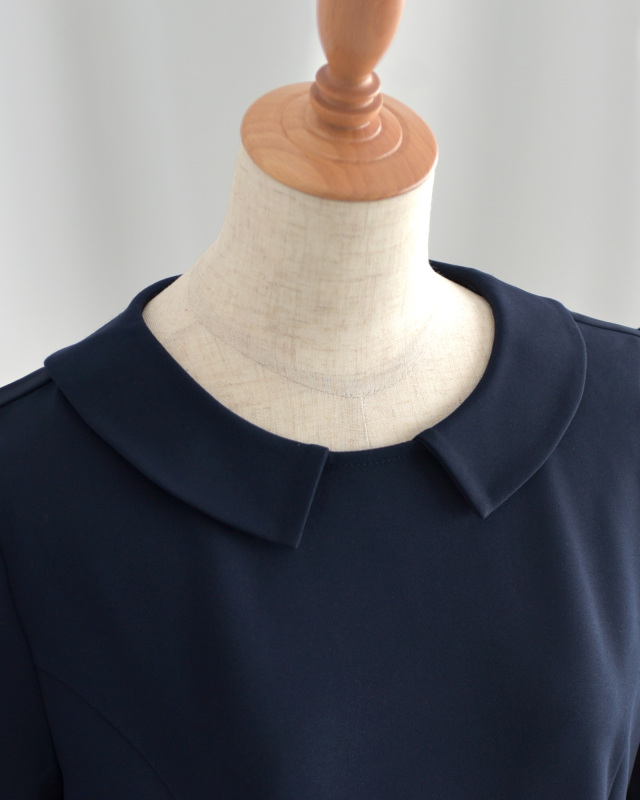 ネイビーワンピースの小襟デザインを拡大、首元をすっきり見せる大人可愛いディテール